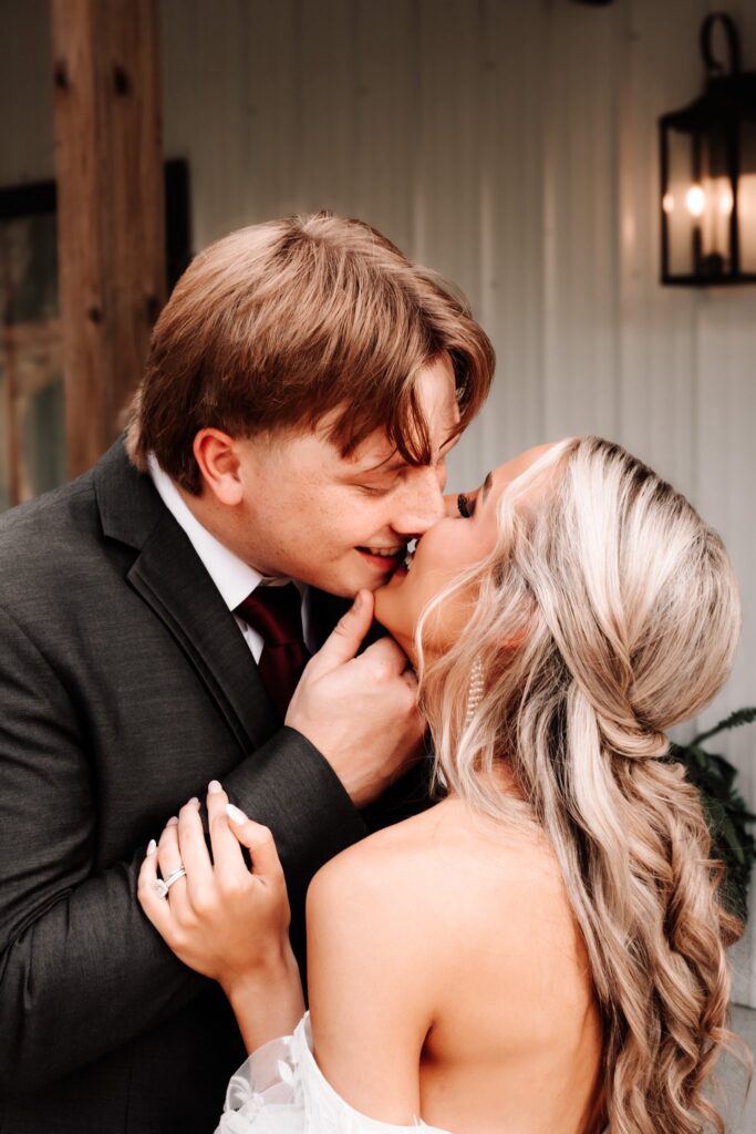 Captured at Lemon Ridge Events, this intimate close-up features a bride and groom sharing a quiet moment. The groom wears a charcoal suit and burgundy tie, while the bride showcases a romantic, curled hairstyle and off-the-shoulder gown. This shot highlights the timeless and elegant photography backdrops available at our Jasper venue. Whether for an elopement or a grand celebration, our space provides the perfect setting for personal milestones. We focus on making every detail effortless, allowing couples to focus on their connection during their special day in the Birmingham area.